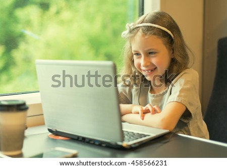 Little girl watching cartoon while traveling by train.