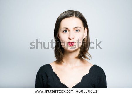slender girl kiss you on the camera, studio photo isolated on a gray background