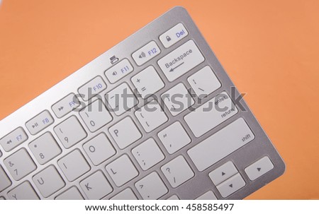 Computer keyboard on orange background. High resolution.
