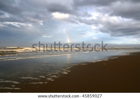 Rainbow and dark grey clouds under the sea