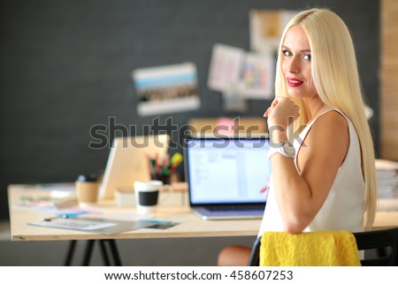 Fashion designers working in studio sitting on the desk