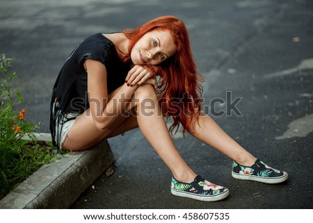 Young beautiful woman sits on rock border