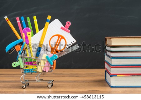 take school supplies in shopping cart with textbook for education