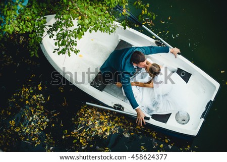 amazing  woman and her man  posing in a boat for photographer Royalty-Free Stock Photo #458624377