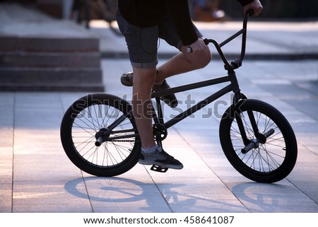 the urban cyclist in motion on the sidewalk
