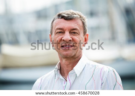 Happy smiling mature man outdoors at sunny spring day Royalty-Free Stock Photo #458670028