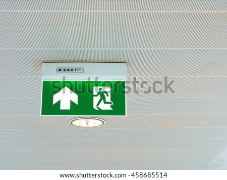 Green emergency exit sign light in the building