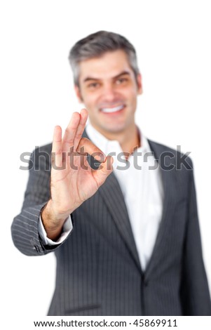 Smiling mature businessman showing OK sign against a white background