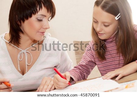Mom and daughter painting on paper - family