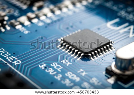 Integrated semiconductor microchip/ microprocessor on blue circuit board representative of the high tech industry and computer science Royalty-Free Stock Photo #458703433