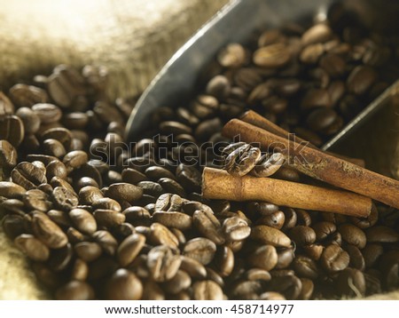 scoop of roasted coffee with cinnamon sticks