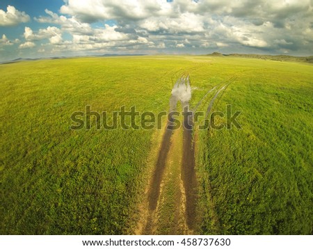 Ground road and cloudy sky in the steppes of Kazakhstan. Aerial photography.