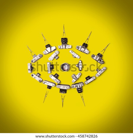 Unusual image of eye, assembled from retro cameras on a yellow background