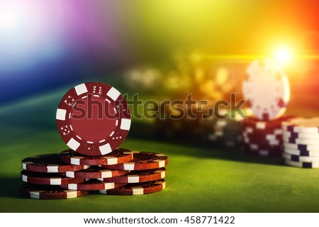 Poker chips of casino on gaming table colorful lighting brightness rainbow color background, close up photography.