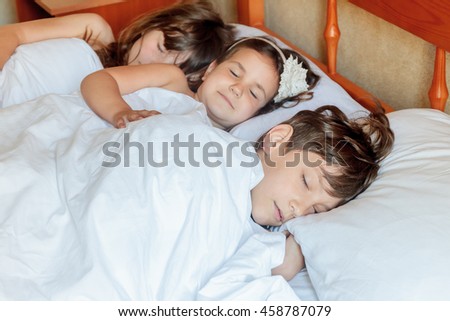 young children - boy and girls - sleeping in bed at home, indoor portrait