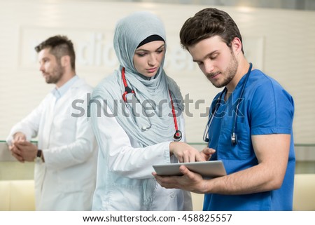 Saudi arab doctors working with a tablet. Royalty-Free Stock Photo #458825557