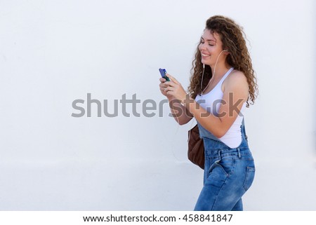 Portrait of smiling teen with cellphone and headphones walking