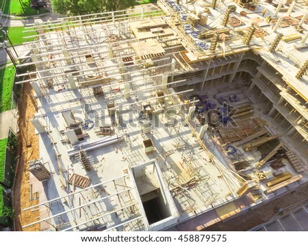 Aerial view of a large civil construction site in progress with lifting crane and workers at early morning in Houston downtown, Texas, US. Industrial, infrastructure development background and concept