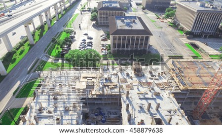 Aerial panorama view of a large civil construction site in progress with lifting crane and workers at early morning in Houston downtown, Texas, US. Industrial, infrastructure development  concept.