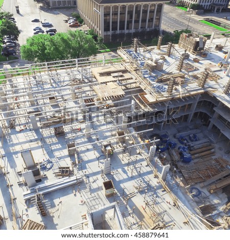 Aerial view of a large civil construction site in progress with lifting crane and workers at early morning in Houston downtown, Texas, US. Industrial, infrastructure development background and concept
