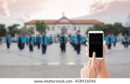 woman use mobile phone and blurred image of people are in protesting