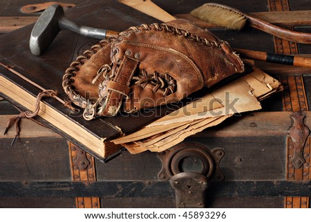 Vintage still life with antique baseball glove, golf club and scrapbook on rustic old steamer trunk. Royalty-Free Stock Photo #45893296