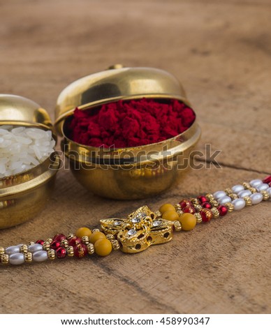 A Rakhi with rice grains and kumkum. An Indian festive background.