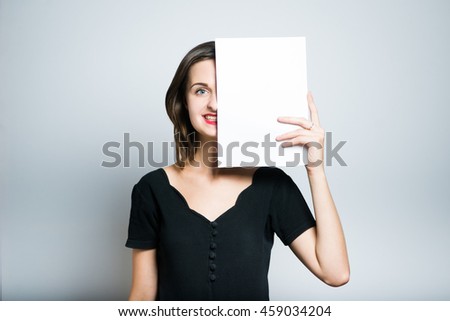 young business woman holding a blank sheet of paper, studio photo isolated on a gray background