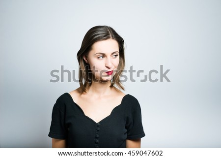 Young business woman doubt, studio photo isolated on a gray background