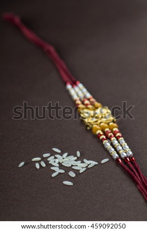 A Rakhi with rice grains. An Indian festive background.