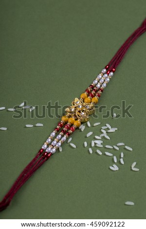 A Rakhi with rice grains. An Indian festive background.