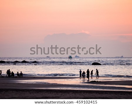 people watching the sunset on the beach