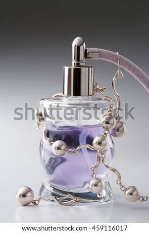 perfume bottle with beads on a gray background