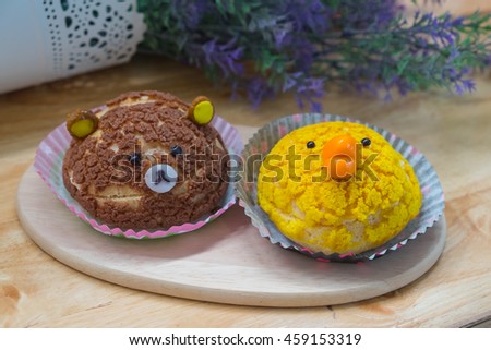 Eddy bear and duck Sweet choux cream in wooden dish