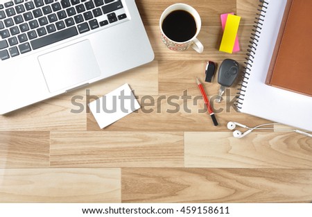 Top view of the working desk of a businessman with blank business card with laptop keyboard, black tea, car key, pen drive and other office articles. The blank card is ready to add contact details. Royalty-Free Stock Photo #459158611