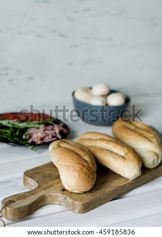 Garlic rolls, mushrooms, tomatoes, ham and fresh herbs for cooking quick snack.