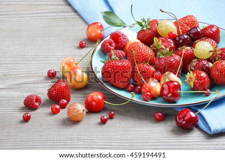 Ceramic plate with mixed berries at old wooden table. Close up, high resolution product. Harvest Concept