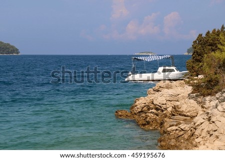 Small boat on the shore. Selective focus, focused on the rocks.