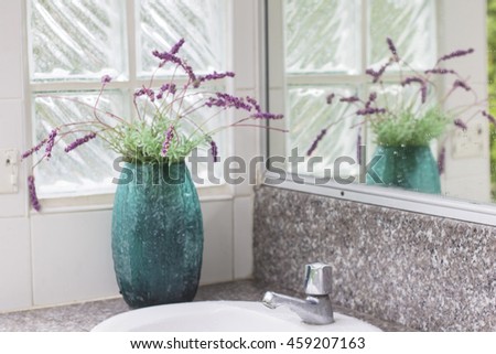 Locations in the men's toilets at a vase of purple flowers to enhance the fresh air. blurred photo.