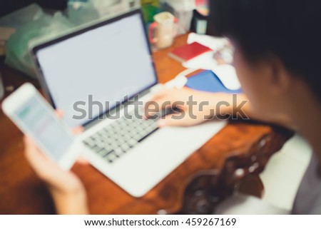 Blurred photo of Man's hands holding a smart phone for online shopping.Vintage tone.