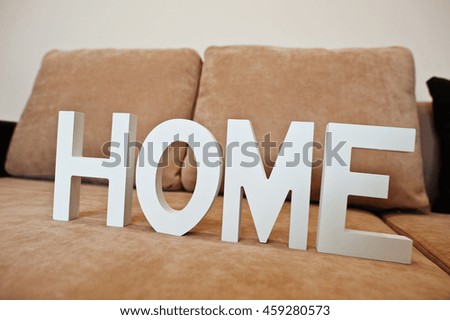 White wooden letters HOME at cofee corner sofa bed at light room