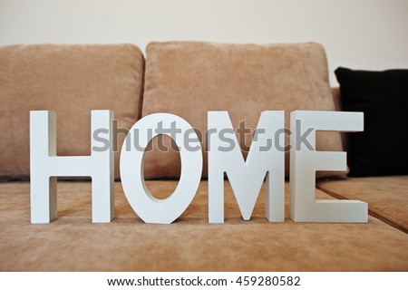 White wooden letters HOME at cofee corner sofa bed at light room