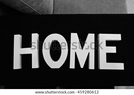 White wooden letters HOME at black background