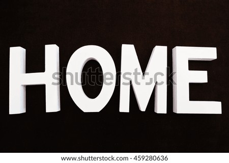 White wooden letters HOME at black background