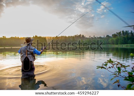 Young man flyfishing at sunrise Royalty-Free Stock Photo #459296227
