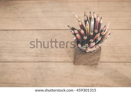 group of color pencils in a wood cup ,retro vintage style top view.