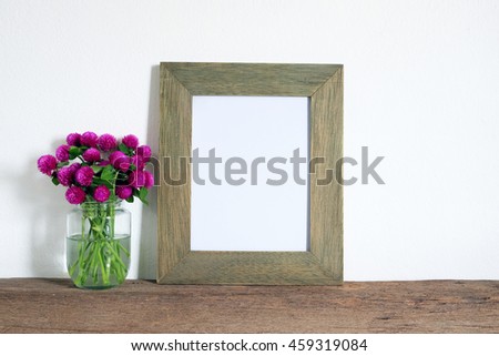 wooden photo frame with pink flower on old wooden shelf
