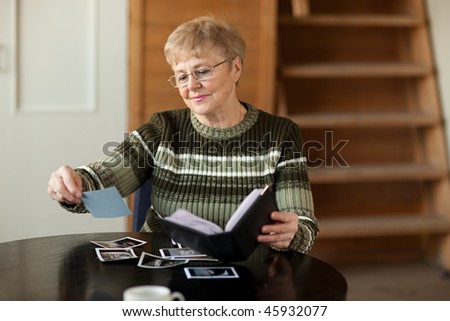 Senior woman viewing photo album in livingroom