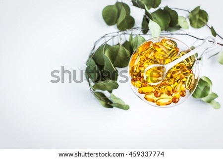Vitamins in The Coupe Champagne Glass With A Small White Spoon and Green Leaves 