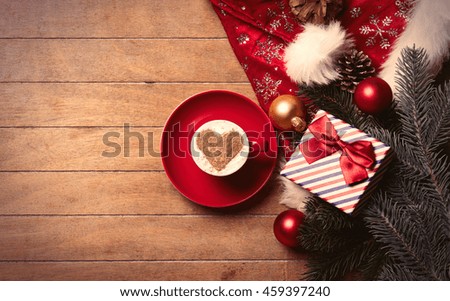 photo of the cup of coffee and christmas decorations on the brown wooden background